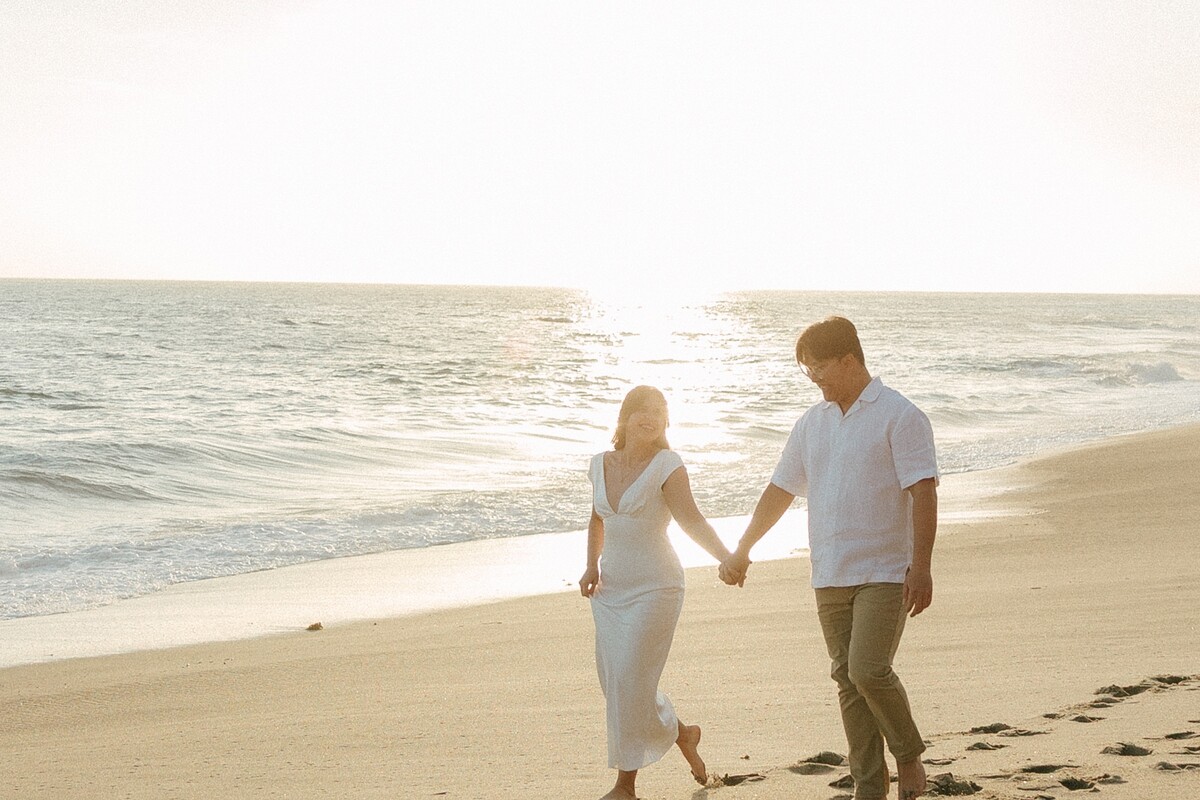Larissa and Tony walking hand in hand at sunset